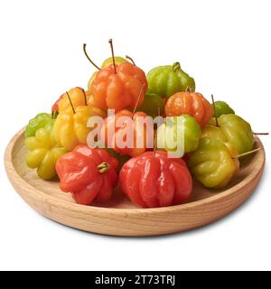 gros plan de cerises du surinam, eugenia uniflora, aka pitanga, cerise brésilienne ou de cayenne, fruits colorés vibrants sur plaque de bois, isolés sur blanc Banque D'Images