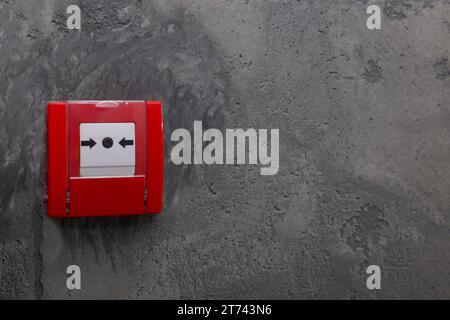 Bouton-poussoir d'alarme incendie sur le mur gris, espace pour le texte Banque D'Images