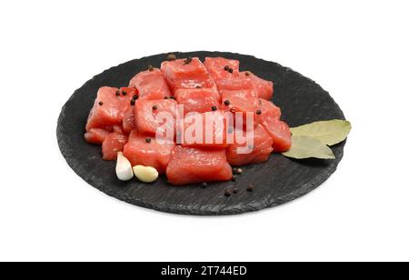 Morceaux de bœuf cru, ail, feuilles de Laurier et grains de poivre isolés sur blanc Banque D'Images