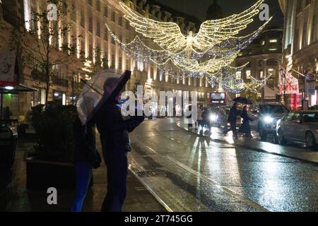 Météo Royaume-Uni, Londres, 12 novembre 2023 : les lumières de Noël sur Regent Street se reflètent sur les routes mouillées par une nuit pluvieuse. Anna Watson/Alamy Live News Banque D'Images