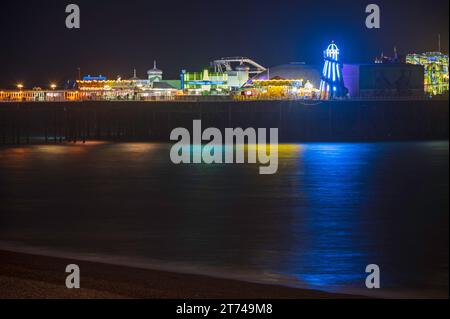 Le parc d'expositions de Palace Pier s'illumine dans la soirée, juste après le coucher du soleil. Brighton, Sussex, Angleterre, Royaume-Uni. Banque D'Images