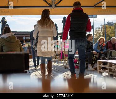 Belgrade, Serbie, 12 novembre 2023 : couple entrant dans une terrasse de restaurant placée sur un pont de barge ancré sur le Danube Banque D'Images