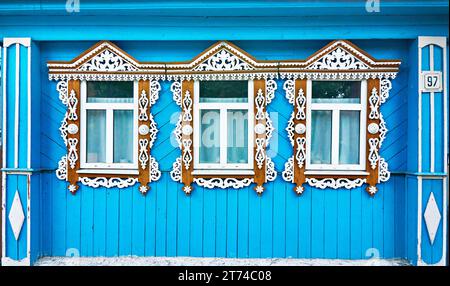 Fenêtres avec plateaux sculptés dans une cabane de village russe Banque D'Images