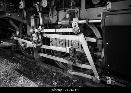 Une photographie en noir et blanc d'un train sur les voies ferrées avec une personne debout à côté Banque D'Images