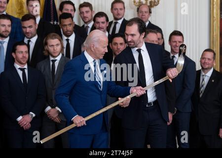 Le président des États-Unis Joe Biden reçoit un bâton de hockey plaqué or du capitaine Mark Stone lors d'une cérémonie d'accueil des Golden Knights de Vegas à la Maison Blanche à Washington, DC, pour célébrer leur victoire en coupe Stanley 2023 le lundi 13 novembre 2023. Crédit : Chris Kleponis/CNP/MediaPunch Banque D'Images