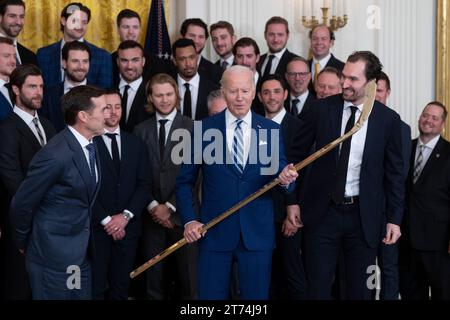 Le président des États-Unis Joe Biden expose une crosse de hockey plaquée or de George McPhee, président des opérations hockey, et du capitaine Mark Stone lors d’une cérémonie d’accueil des Golden Knights de Vegas à la Maison Blanche à Washington, DC, pour célébrer leur victoire de la coupe Stanley 2023, le lundi 13 novembre 2023.crédit : Chris Kleponis/CNP/MediaPunch Banque D'Images