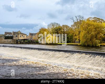 Weir sur la rivière Wharfe à Otley, avec le restaurant Buon Apps vu en automne. ROYAUME-UNI Banque D'Images