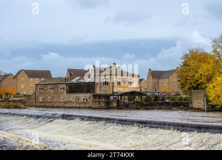 Weir sur la rivière Wharfe à Otley, avec le restaurant Buon Apps vu en automne Banque D'Images