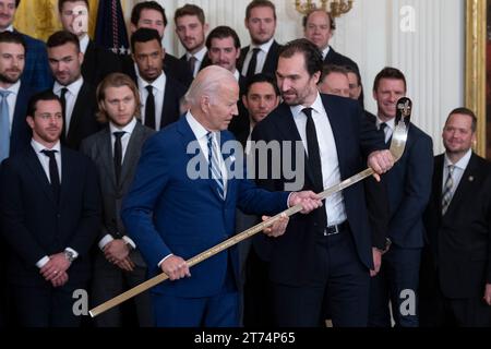 Le président des États-Unis Joe Biden reçoit une crosse de hockey plaquée or du capitaine Mark Stone lors d’une cérémonie d’accueil des Golden Knights de Vegas à la Maison Blanche à Washington, DC, pour célébrer leur victoire en coupe Stanley 2023, le lundi 13 novembre 2023. Crédit : Chris Kleponis/CNP Banque D'Images