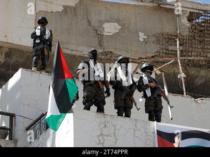 Des Yéménites brandissent des drapeaux palestiniens, dansent et font du vélo lors d'une veillée de solidarité avec le peuple palestinien, à Sanaa, Yémen, le 13 novembre 2023. Des milliers d’Israéliens et de Palestiniens sont morts depuis que le groupe militant Hamas a lancé une attaque sans précédent contre Israël depuis la bande de Gaza le 07 octobre et depuis les frappes israéliennes contre l’enclave palestinienne. Banque D'Images