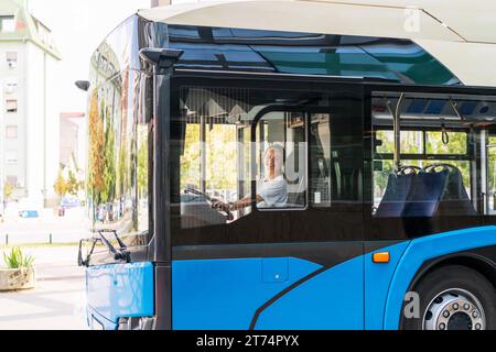 Femme chauffeur de bus. Une jeune personne adulte de sexe féminin conduit un trolley-bus. Banque D'Images