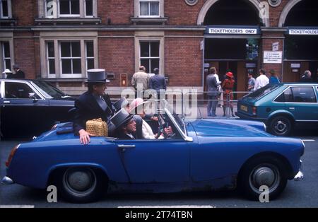 Austin Healey voiture 1980s groupe les gens dans la voiture de sport à toit ouvert quittant Royal Ascot course de chevaux. Les Racegoers partent après une journée aux courses écrasées dans une vieille Austin Healey. Ascot, Berkshire, Angleterre vers juin 1985. ROYAUME-UNI HOMER SYKES Banque D'Images