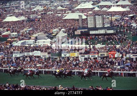 Derby Day, Epsom Downs, la course hippique Derby. Les chevaux arrivent en fin de course. La foule de spectateurs 'sur la colline', sur le côté moins cher non payant de la piste de course. Parieurs profitant d'une journée à Epsom Downs, Surrey, Angleterre juin 1985 1980 Royaume-Uni HOMER SYKES Banque D'Images