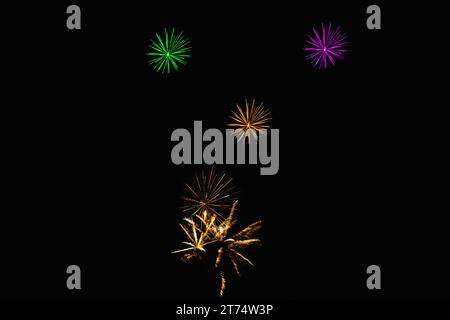Nuit du nouvel an, Diwali, étoiles de nuit de feu de joie et explosions de fusée sur fond noir ciel avec rouge, vert, bleu, violet, or feux d'artifice de couleur Banque D'Images