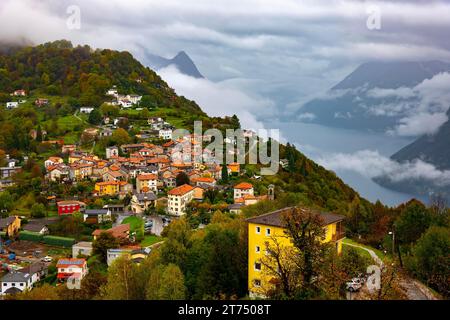 Vue aérienne sur Mountainscape et le village alpin bre avec la forêt d'automne et le lac de Lugano dans une journée nuageuse à Monte bre, Lugano, Tessin, Suisse Banque D'Images