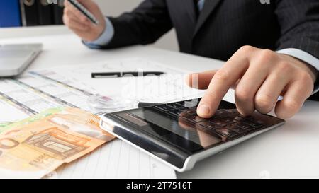 Homme d'affaires calculant les chiffres financiers en gros plan Banque D'Images