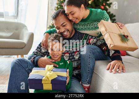 Belle joyeuse famille afro-américaine échangeant des cadeaux et serrant chaleureusement, Noël Banque D'Images