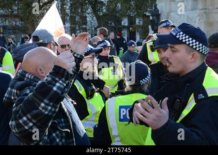 Les policiers de met interrogent et fouillent les contre-manifestants avant le début de la marche pro-palestinienne le jour de l'Armistice 11 novembre 2023. Banque D'Images