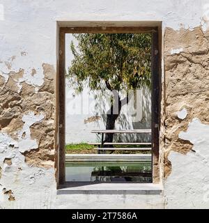 Fenêtre dans un mur, cour intérieure de la Biblioteca Municipal Alvaro de Campos, ancienne prison, Tavira, Portugal Banque D'Images