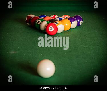 Gros plan d'une table de billard avec des boules de billard vibrantes, invitant à un jeu de précision et d'habileté Banque D'Images