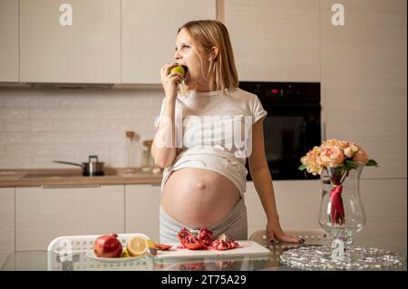 Vue de face femme enceinte mangeant des pommes Banque D'Images
