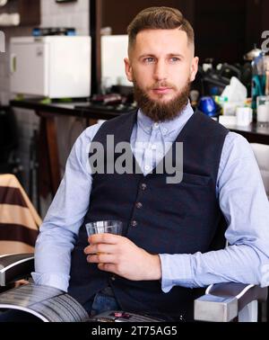 Homme tenant un barbier à whisky en verre Banque D'Images