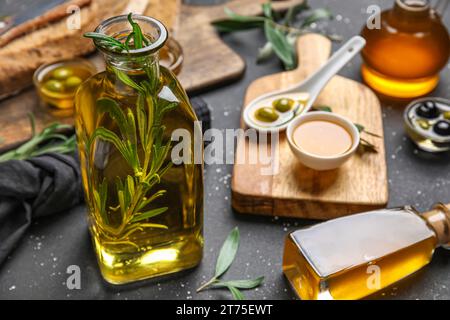 Bouteilles d'huile d'olive fraîche sur fond noir Banque D'Images