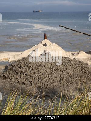 Prerow, Allemagne. 13 novembre 2023. Le mélange eau-sable pour le réapprovisionnement en sable sort d'un tuyau sur la plage. Depuis mi-octobre, la plage et la dune ont été renforcées de 720 000 mètres cubes de sable sur une longueur de près de neuf kilomètres. Le projet de dix millions d'euros devrait être achevé à la fin du mois de mars 2024. Crédit : Bernd Wüstneck/dpa/Alamy Live News Banque D'Images