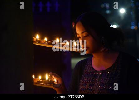 Guwahati, Guwahati, Inde. 12 novembre 2023. Une fille allume des lampes en terre pendant la célébration de Diwali, festival de la lumière à Guwahati Assam Inde le dimanche 12 novembre 2023.photo-DASARATH DEKA (crédit image : © Dasarath Deka/ZUMA Press Wire) USAGE ÉDITORIAL SEULEMENT! Non destiné à UN USAGE commercial ! Banque D'Images
