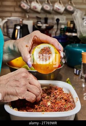 Le chef farce les courgettes avec de la viande hachée, des œufs, de l'ail et des herbes Banque D'Images