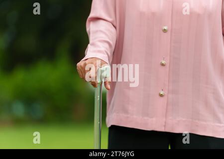 close up femme senior avec bâton de marche dans le parc Banque D'Images