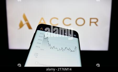 Smartphone avec le site Internet de la société hôtelière française Accor S.A. devant le logo de l'entreprise. Effectuez le focus sur le coin supérieur gauche de l'écran du téléphone. Banque D'Images