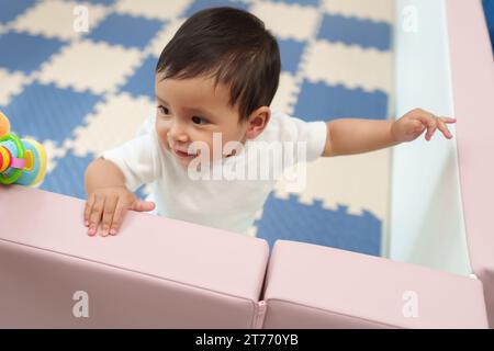 bébé bébé heureux debout dans une clôture de parc Banque D'Images