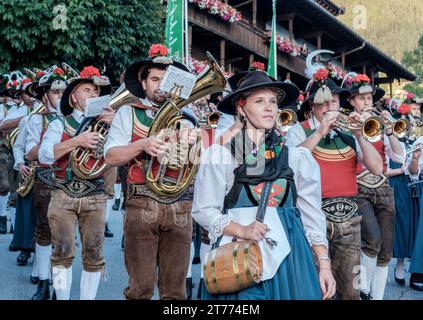 Orchestre de musique locale d'Alpbach Autriche, en robe tyrolienne traditionnelle, marche dans le centre de la ville, jouant des instruments. Banque D'Images