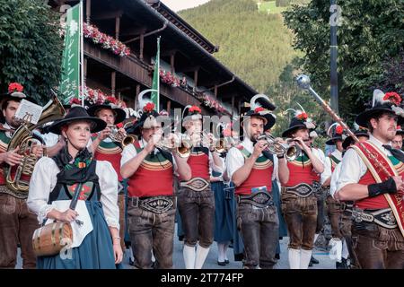 Orchestre de musique locale d'Alpbach Autriche, en robe tyrolienne traditionnelle, marche dans le centre de la ville, jouant des instruments. Banque D'Images