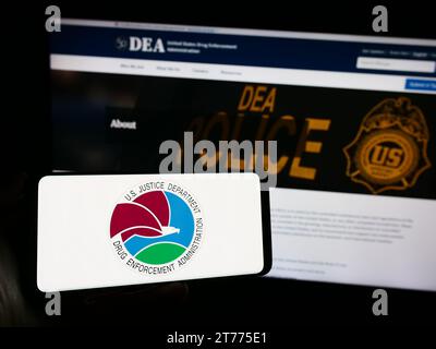 Personne tenant un smartphone avec sceau de la Drug Enforcement Administration (DEA) des États-Unis devant le site Web. Concentrez-vous sur l'affichage du téléphone. Banque D'Images