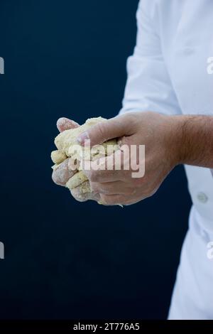 Close up of a chef mains pétrissant la pâte à pizza Banque D'Images