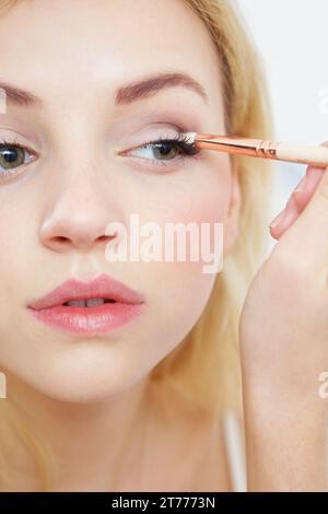 Close up of Young Woman Applying Eye Shadow Banque D'Images