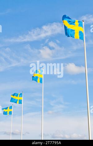 série de drapeaux suédois avec nuage contre ciel bleu Banque D'Images