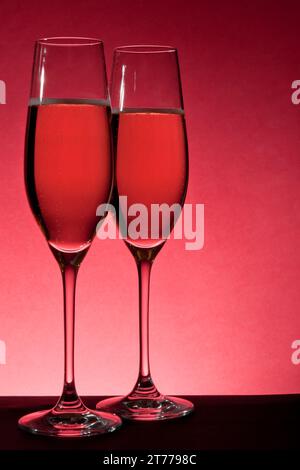 deux verres pleins de champagne sur fond rouge Banque D'Images