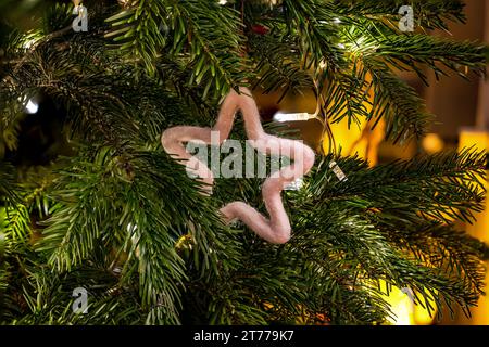 Belle étoile en feutre accroche sur le sapin de Noël sur une branche de sapin pour la fête de Noël Banque D'Images