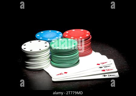 quatre piles de fiches colorées sur un as de poker Banque D'Images