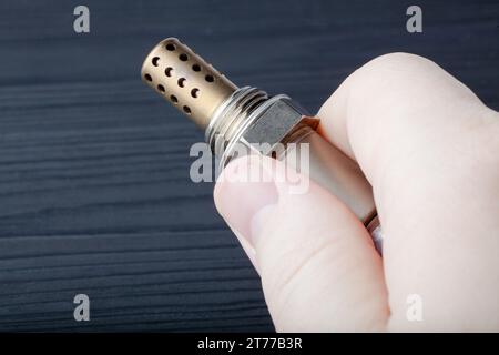 Capteur d'oxygène pour moteurs à essence et diesel dans la main. la sonde lambda est un composant fiable pour optimiser les performances de votre voiture. Banque D'Images