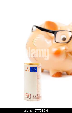 billet de cinquante euros devant une tirelire non focalisée avec des lunettes sur fond blanc avec espace pour le texte, concept pour les affaires et économiser de l'argent Banque D'Images