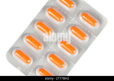dessus de la vue des pilules orange emballées dans blister isolé sur fond blanc Banque D'Images