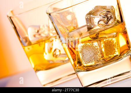 une paire de verres de whisky avec de la glace sur une table de bar blanche Banque D'Images