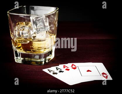 cartes à jouer au poker près du verre wiskey sur la vieille table en bois avec espace pour le texte Banque D'Images