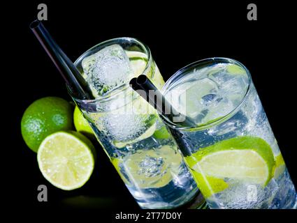 deux verres avec cocktail et glace avec tranche de citron vert sur table noire, ambiance discothèque Banque D'Images