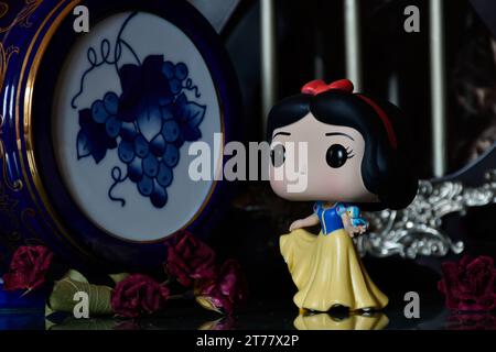 Funko Pop figurine d'action de la princesse Disney Blanche-neige avec oiseau. Beau palais, royaume fabuleux, colonnes, roses rouges, fût bleu vintage. Banque D'Images