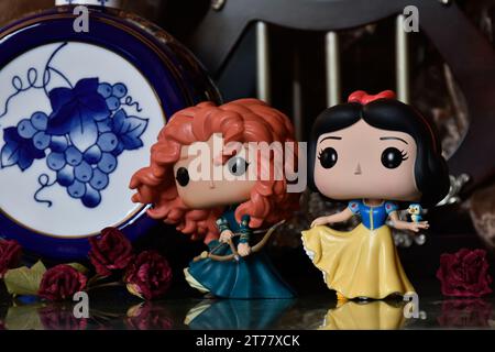 Figurines Funko Pop des princesses Disney Merida (Brave) et Blanche-neige. Château médiéval, royaume fabuleux, roses rouges, tonneau bleu porcelaine. Banque D'Images